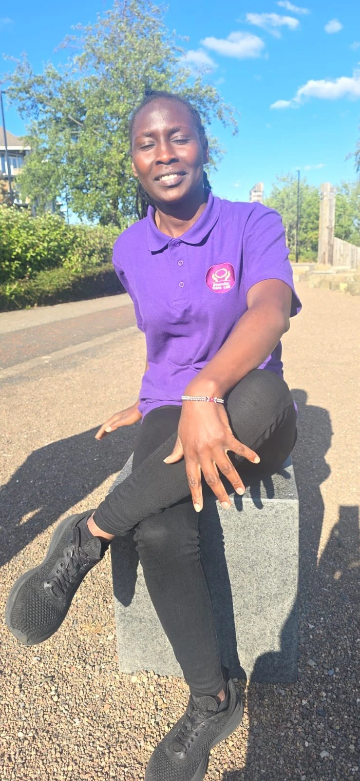 Eternity Care team member in uniform sitting outside on a bench