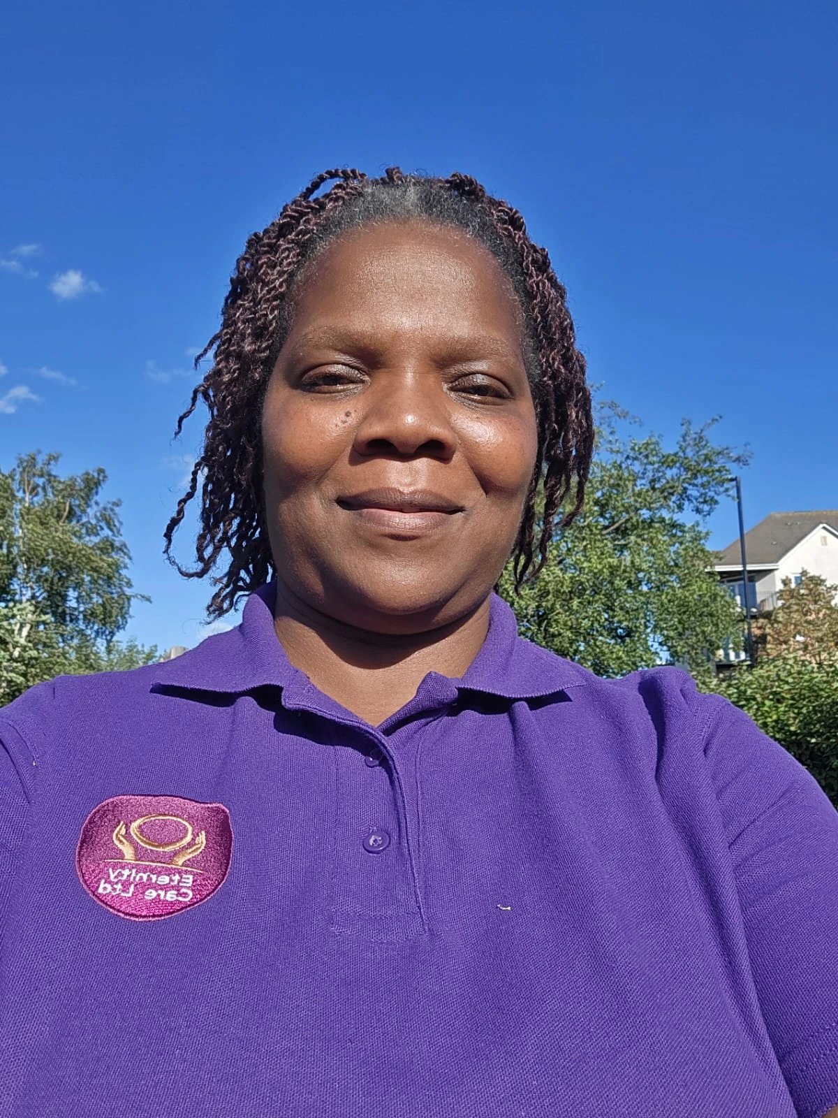 Eternity Care team member in uniform outdoors on a sunny day